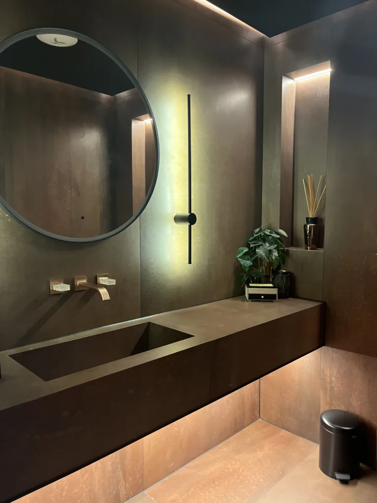Luxury bathroom interior with integrated stone vanity, textured wall finishes and soft architectural lighting