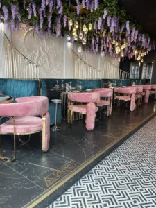 Luxury hospitality interior with dark marble flooring, bespoke pink seating and decorative wall finishes in a high-end restaurant setting