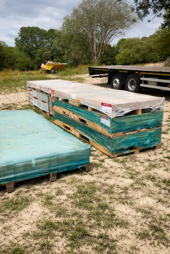 Large format porcelain slabs delivered on pallets at a residential construction site in the UK
